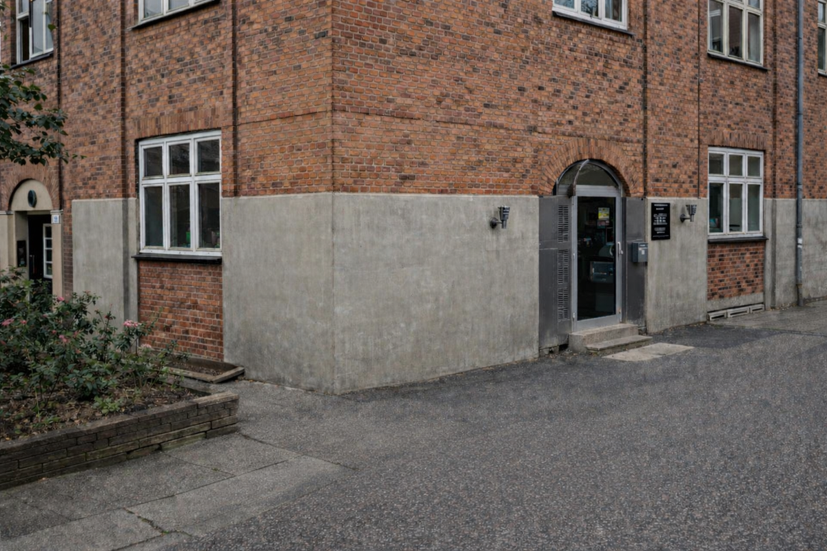 Indgangen til SimplyMeals i Valby ved en rød murstensbygning.