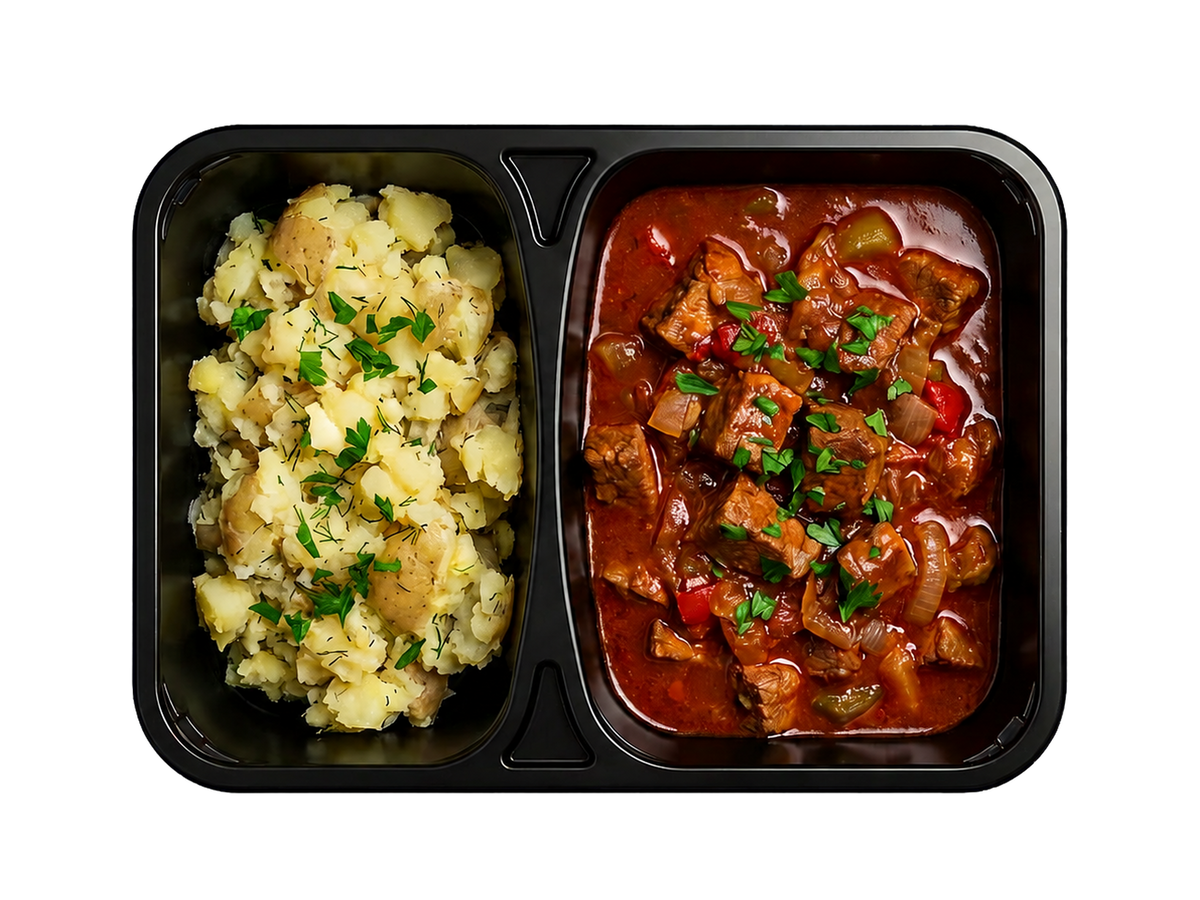 Ungarsk gullasch af mørt grisekød med knuste kartofler og urter.